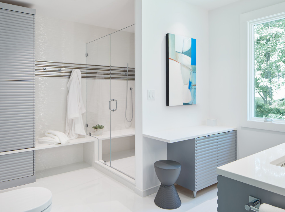 Inredning av ett modernt stort vit vitt en-suite badrum, med grå skåp, en dusch i en alkov, vit kakel, vita väggar, ett undermonterad handfat, vitt golv, dusch med gångjärnsdörr, en vägghängd toalettstol, klinkergolv i porslin och bänkskiva i kvarts