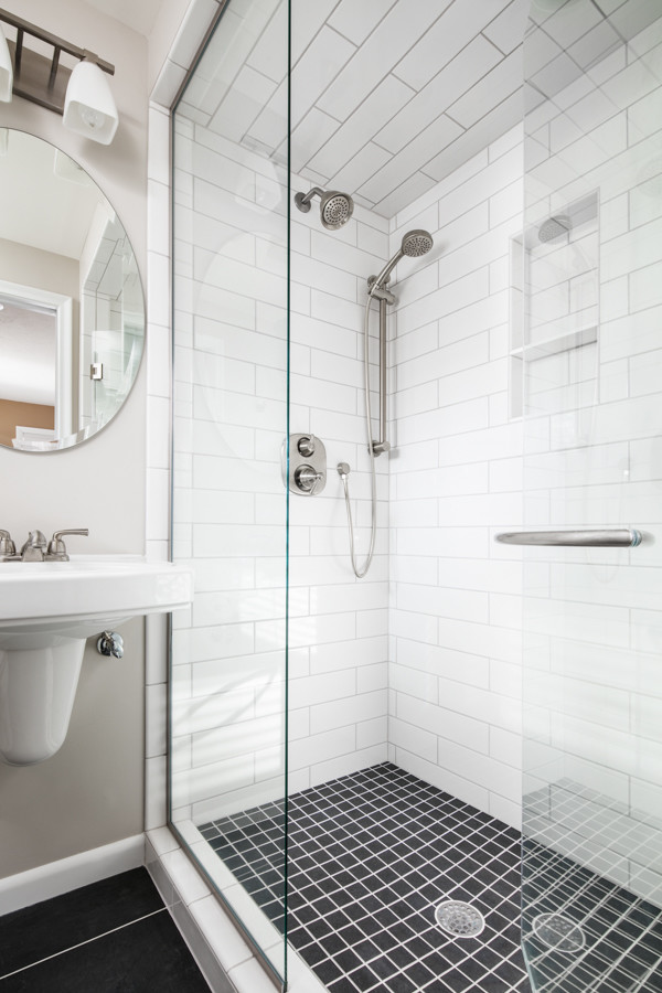 Пример оригинального дизайна: маленькая ванная комната в стиле неоклассика (современная классика) с душем в нише, раздельным унитазом, белой плиткой, плиткой кабанчик, серыми стенами, полом из керамической плитки, душевой кабиной, подвесной раковиной, черным полом и душем с распашными дверями для на участке и в саду