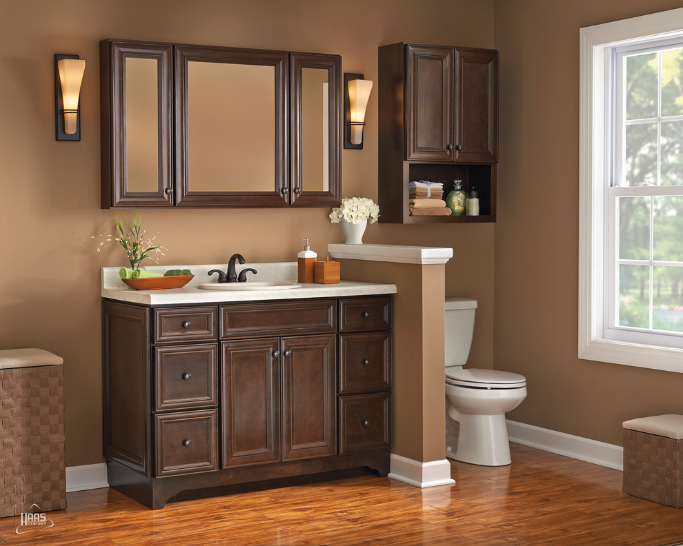 Ejemplo de cuarto de baño actual con armarios con paneles empotrados y puertas de armario de madera en tonos medios