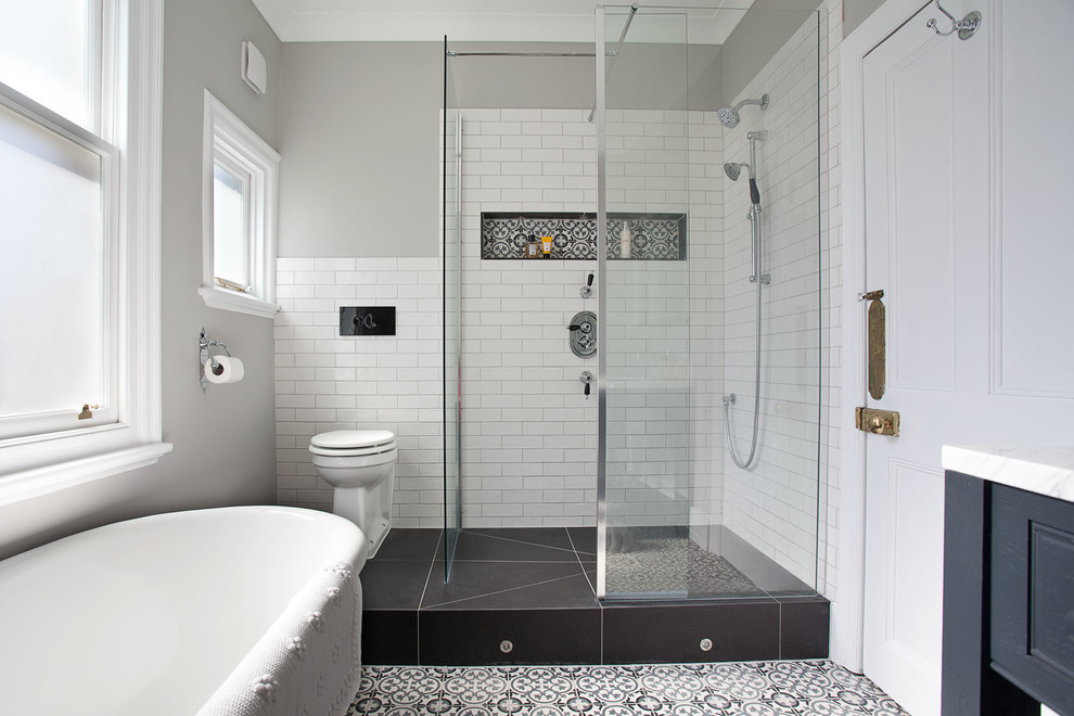 На фото: ванная комната среднего размера в современном стиле с фасадами в стиле шейкер, серыми фасадами, отдельно стоящей ванной, душевой комнатой, унитазом-моноблоком, белой плиткой, плиткой кабанчик, серыми стенами, полом из цементной плитки, накладной раковиной, мраморной столешницей, разноцветным полом и открытым душем с