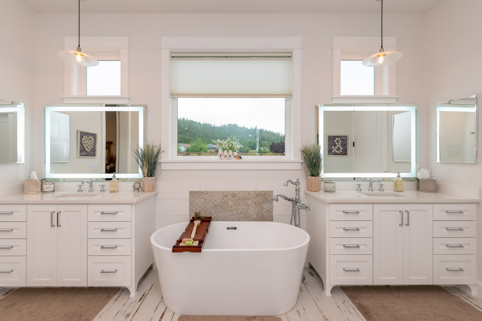 Foto på ett stort vintage vit en-suite badrum, med skåp i shakerstil, vita skåp, ett fristående badkar, en öppen dusch, en toalettstol med separat cisternkåpa, vit kakel, glaskakel, vita väggar, laminatgolv, marmorbänkskiva, vitt golv och med dusch som är öppen