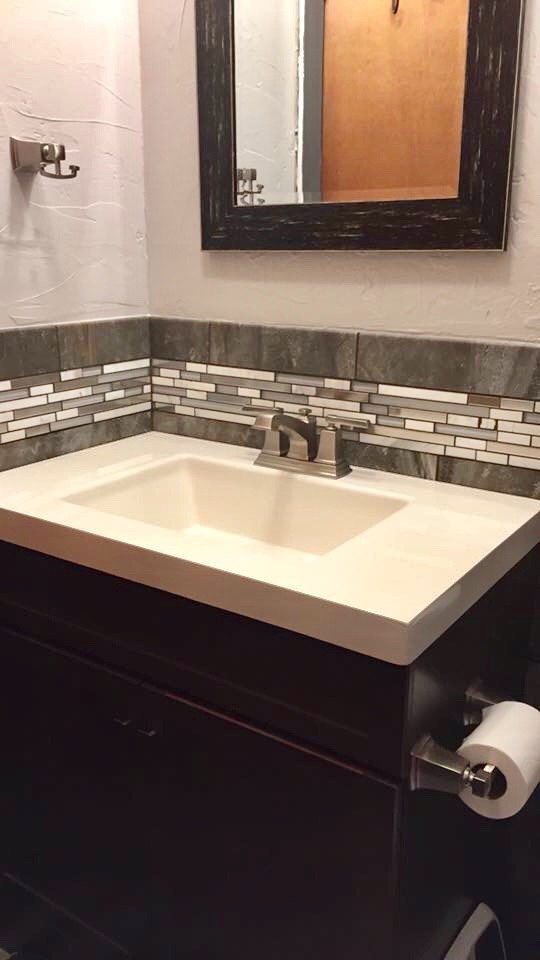 Esempio di una stanza da bagno minimal con ante lisce, piastrelle nere, pistrelle in bianco e nero, piastrelle a listelli, pareti bianche, lavabo integrato e top bianco
