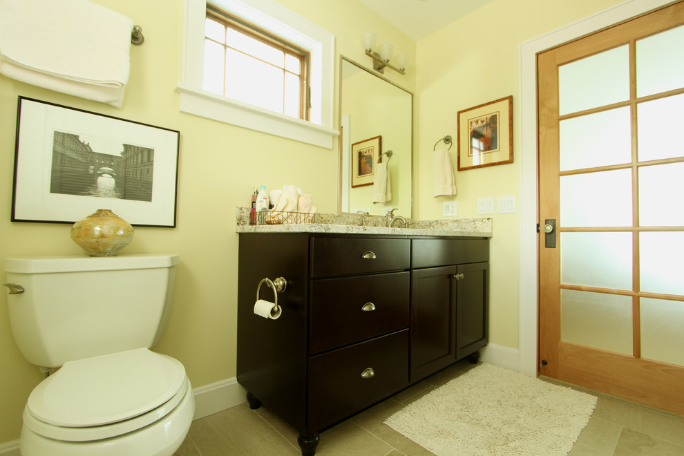Idee per una stanza da bagno con doccia classica di medie dimensioni con ante in legno bruno, doccia alcova, WC a due pezzi, pareti gialle, pavimento in travertino, lavabo sottopiano, top in granito, ante lisce, piastrelle beige e piastrelle in pietra