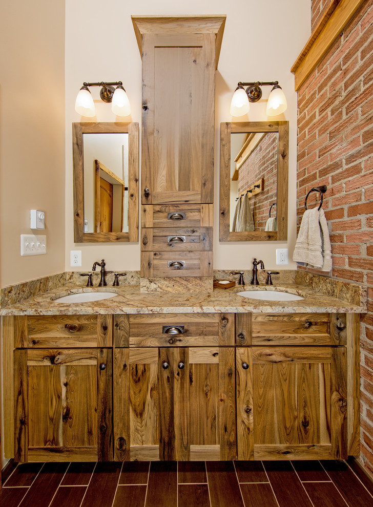 Cette photo montre une salle de bain montagne en bois brun avec un placard à porte shaker, WC séparés, un carrelage marron, des carreaux de porcelaine, un mur beige, un sol en carrelage de porcelaine, un lavabo encastré et un plan de toilette en granite.