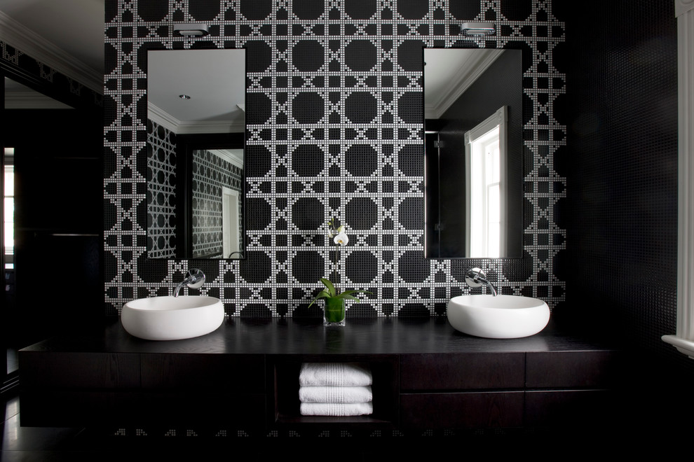 Idée de décoration pour une salle de bain design avec un placard à porte plane, des portes de placard noires, un carrelage noir et blanc, un mur noir et une vasque.