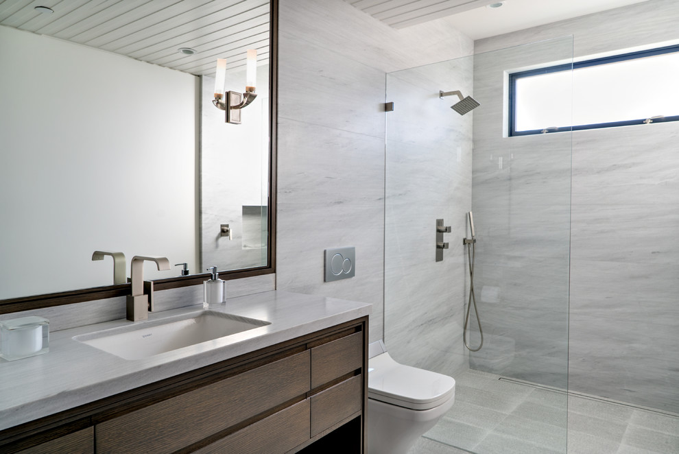 Exempel på ett mellanstort modernt badrum med dusch, med släta luckor, skåp i mörkt trä, en öppen dusch, en vägghängd toalettstol, grå kakel, marmorkakel, ett undermonterad handfat och med dusch som är öppen