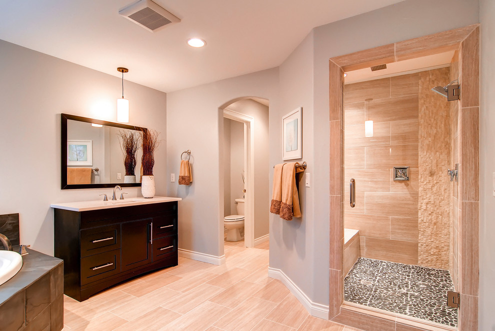 This is an example of a classic bathroom in Denver with a submerged sink, shaker cabinets, dark wood cabinets, a built-in bath, an alcove shower, beige tiles, beige floors and a shower bench.