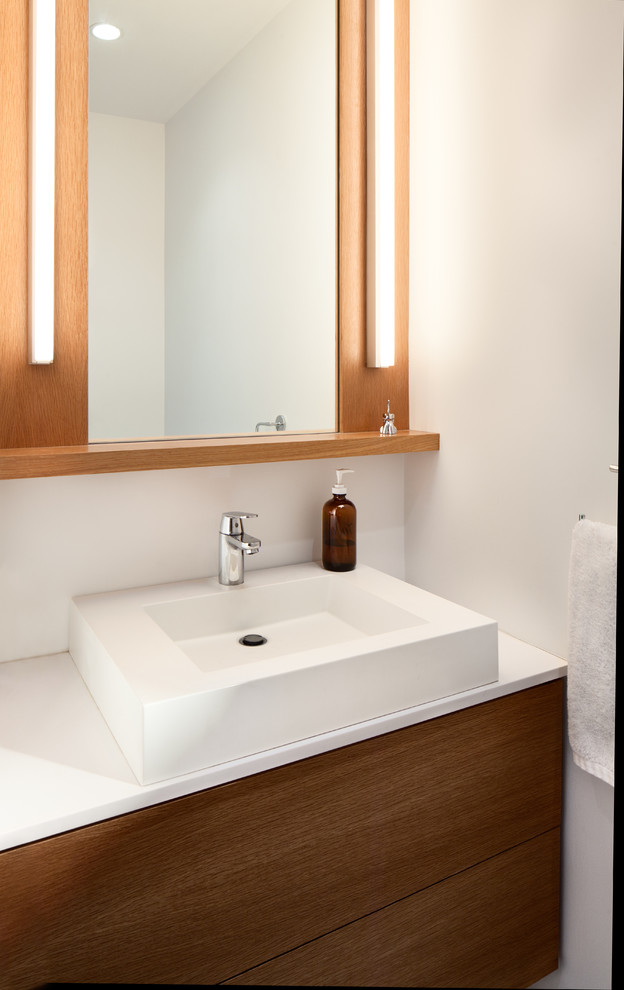 Exempel på ett litet modernt badrum med dusch, med ett fristående handfat, släta luckor, skåp i mellenmörkt trä, bänkskiva i kvarts, en dusch i en alkov, en vägghängd toalettstol, blå kakel, vita väggar och marmorgolv