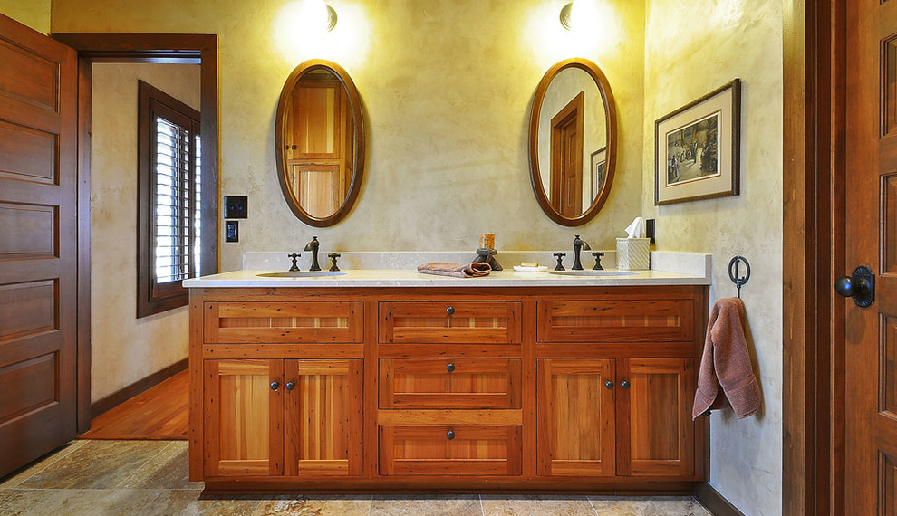 Idee per una stanza da bagno country con lavabo sottopiano, ante con bugna sagomata, top in marmo, piastrelle beige e lastra di pietra