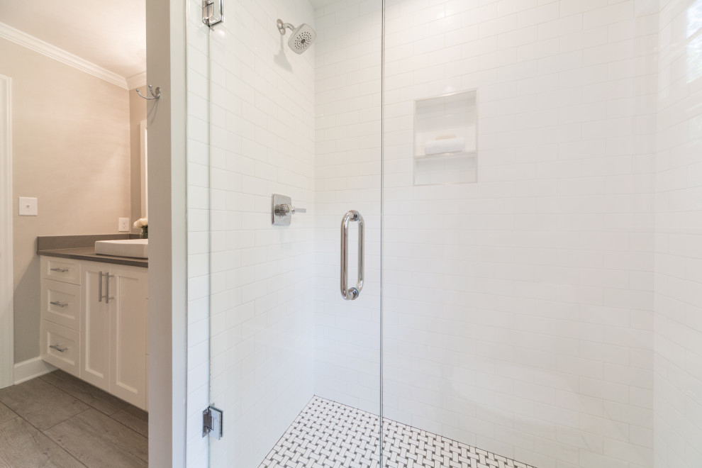 Example of a mid-sized classic 3/4 white tile and ceramic tile ceramic tile and gray floor alcove shower design in Charlotte with shaker cabinets, white cabinets, a one-piece toilet, gray walls, a vessel sink, quartzite countertops, a hinged shower door and gray countertops