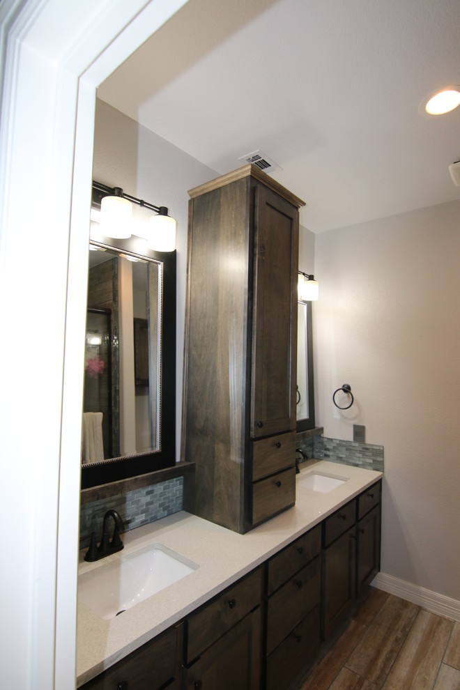 Cette photo montre une salle de bain moderne en bois brun de taille moyenne pour enfant avec un placard à porte shaker, un carrelage gris, un carrelage en pâte de verre, un mur bleu, un sol en carrelage de porcelaine, un lavabo encastré et un plan de toilette en quartz modifié.