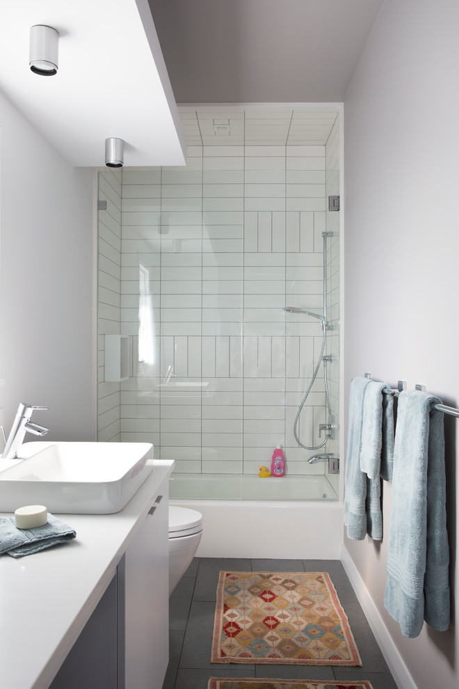 Свежая идея для дизайна: большая ванная комната в современном стиле с белыми фасадами, столешницей из искусственного кварца, серыми стенами, настольной раковиной, ванной в нише, душем над ванной и плиткой кабанчик - отличное фото интерьера