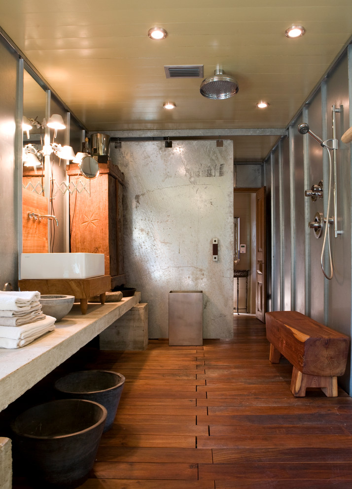 Exemple d'une salle d'eau industrielle avec une vasque, un plan de toilette en béton, une douche ouverte et un sol en bois brun.