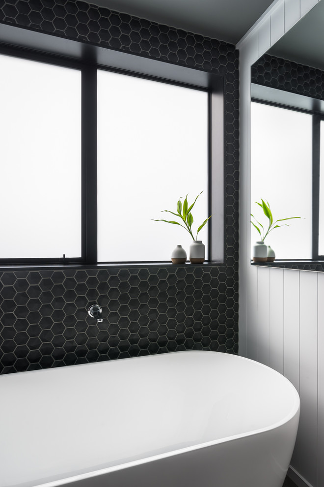 ウェリントンにある高級な中くらいなコンテンポラリースタイルのおしゃれな浴室 (置き型浴槽、黒い壁) の写真