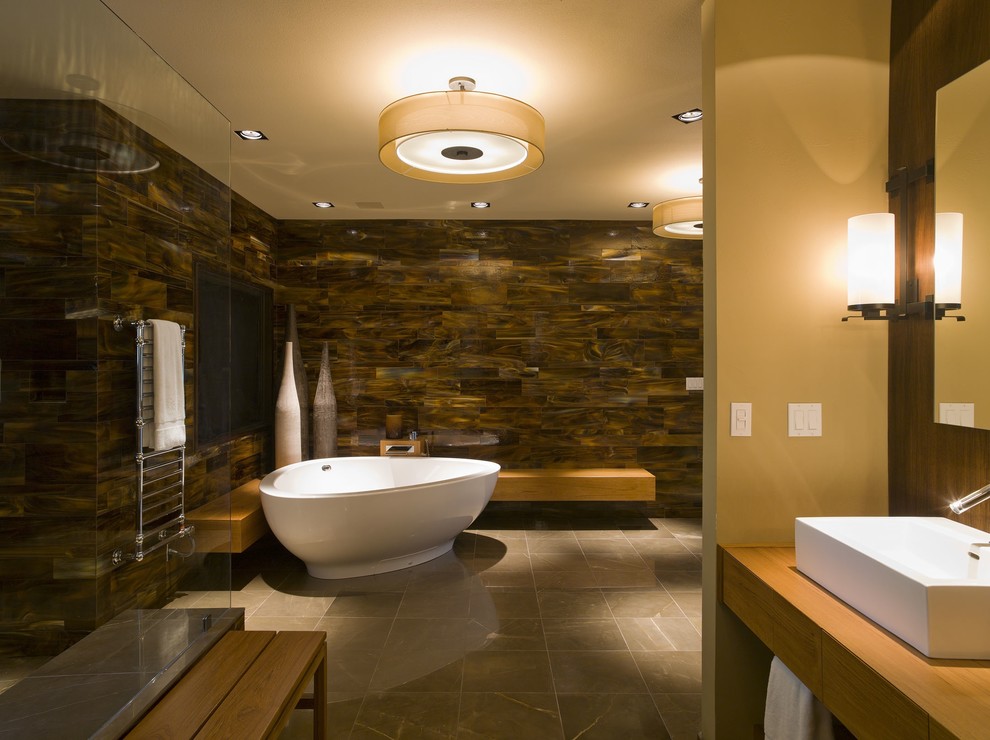 This is an example of a contemporary bathroom in Austin with a freestanding bath, a vessel sink and feature lighting.