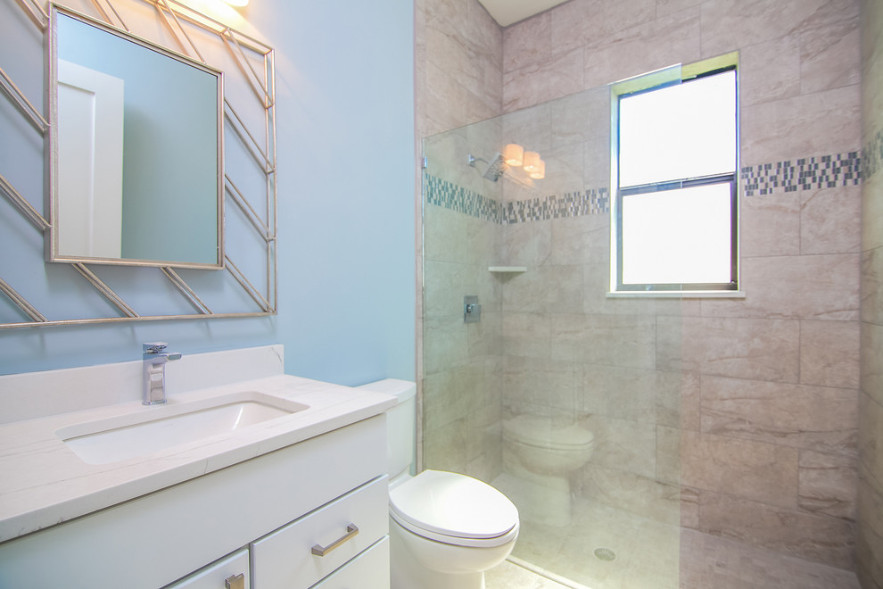 На фото: детская ванная комната среднего размера в стиле неоклассика (современная классика) с фасадами в стиле шейкер, белыми фасадами, унитазом-моноблоком, серой плиткой, керамогранитной плиткой, синими стенами, полом из керамогранита, врезной раковиной, столешницей из искусственного кварца, коричневым полом и открытым душем