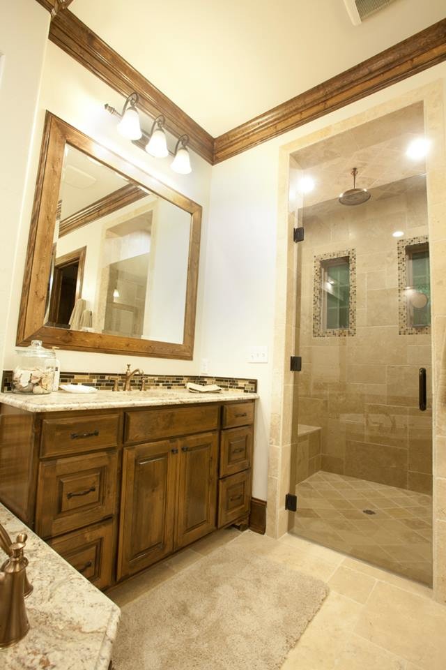 Idéer för mellanstora medelhavsstil en-suite badrum, med luckor med infälld panel, skåp i mellenmörkt trä, granitbänkskiva, beige kakel, porslinskakel, travertin golv, ett hörnbadkar, en dusch i en alkov och ett undermonterad handfat