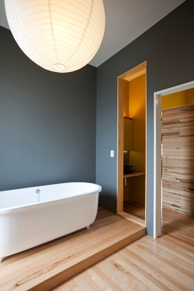 Inredning av ett modernt mellanstort badrum med dusch, med ett fristående badkar, blå väggar och ljust trägolv