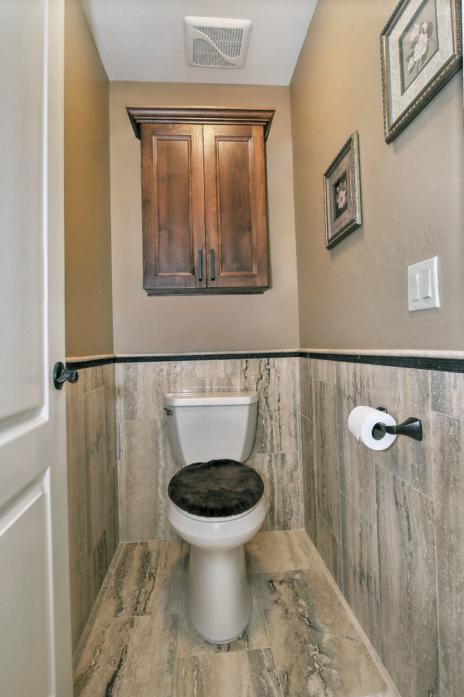 Bild på ett stort vintage toalett, med skåp i mörkt trä, en toalettstol med hel cisternkåpa, beige kakel, travertinkakel, beige väggar, travertin golv, ett undermonterad handfat, granitbänkskiva och brunt golv