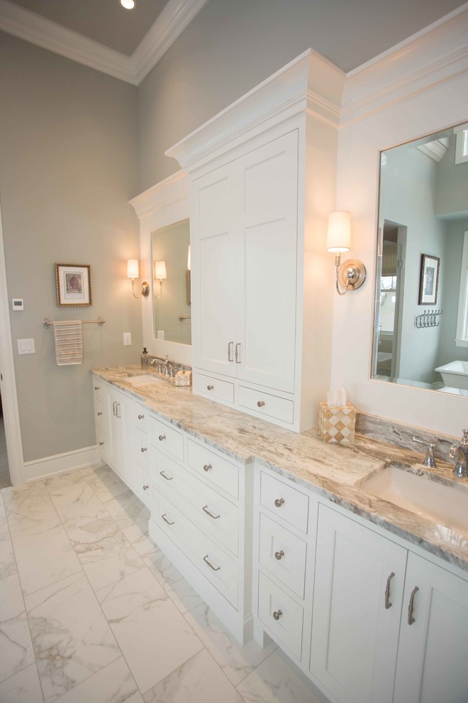 Imagen de cuarto de baño principal tradicional renovado grande con armarios con paneles empotrados, puertas de armario blancas, paredes beige, suelo de mármol, lavabo bajoencimera y encimera de mármol