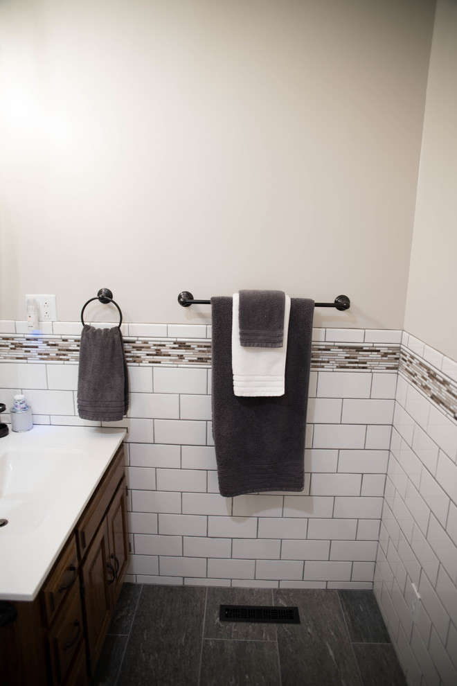 Idéer för ett mellanstort klassiskt badrum med dusch, med en toalettstol med separat cisternkåpa, vit kakel, tunnelbanekakel, beige väggar, ett integrerad handfat, luckor med upphöjd panel, skåp i mörkt trä, klinkergolv i porslin, bänkskiva i kvarts och grått golv