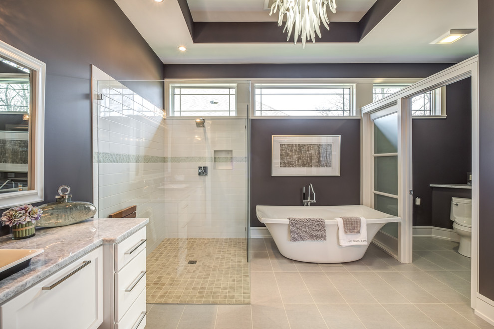 Example of a large transitional master subway tile bathroom design in Cincinnati with shaker cabinets, white cabinets, a two-piece toilet, purple walls, a vessel sink and marble countertops