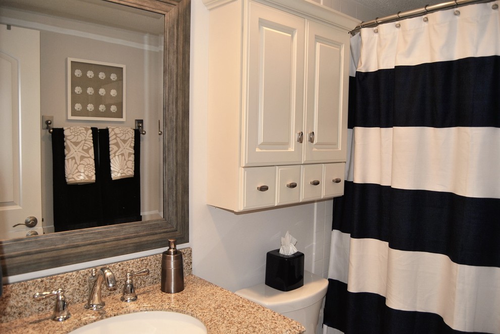 Inredning av ett maritimt litet badrum, med luckor med upphöjd panel, vita skåp, ett platsbyggt badkar, en dusch/badkar-kombination, beige kakel, keramikplattor, beige väggar, klinkergolv i keramik, ett undermonterad handfat och granitbänkskiva