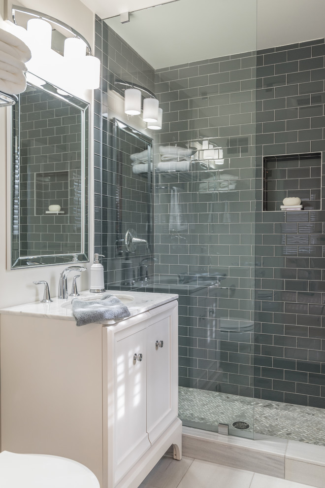 Inredning av ett klassiskt litet badrum med dusch, med släta luckor, vita skåp, en öppen dusch, en toalettstol med separat cisternkåpa, grå kakel, glaskakel, vita väggar, marmorgolv, ett nedsänkt handfat, marmorbänkskiva, vitt golv och med dusch som är öppen