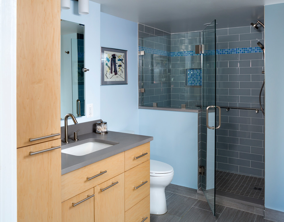 Foto på ett litet funkis badrum, med släta luckor, skåp i ljust trä, blå kakel och vita väggar