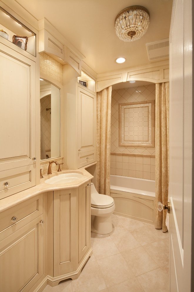 Example of a mid-sized classic beige tile and porcelain tile travertine floor and beige floor bathroom design in DC Metro with raised-panel cabinets, beige cabinets, a one-piece toilet, beige walls and an undermount sink