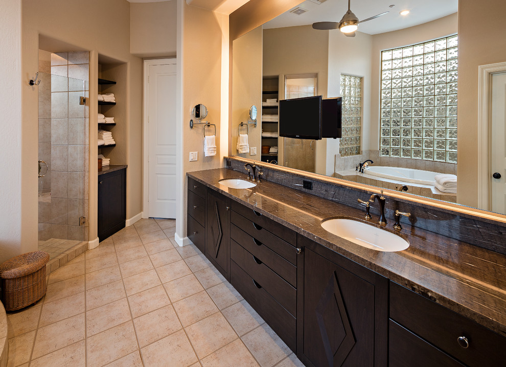 Cette image montre une salle de bain traditionnelle en bois foncé avec un placard en trompe-l'oeil, un lavabo encastré et un plan de toilette en granite.
