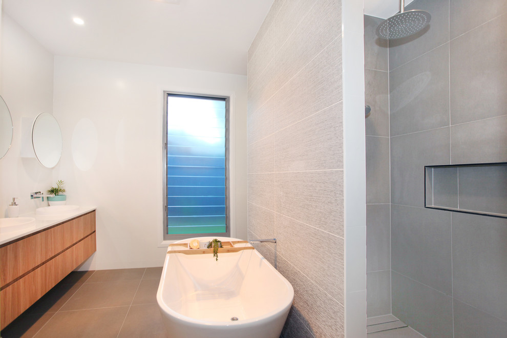 Inspiration for a medium sized contemporary ensuite bathroom in Sunshine Coast with freestanding cabinets, light wood cabinets, a freestanding bath, an alcove shower, blue tiles, ceramic tiles, white walls, ceramic flooring, a built-in sink, engineered stone worktops, beige floors, a hinged door and white worktops.