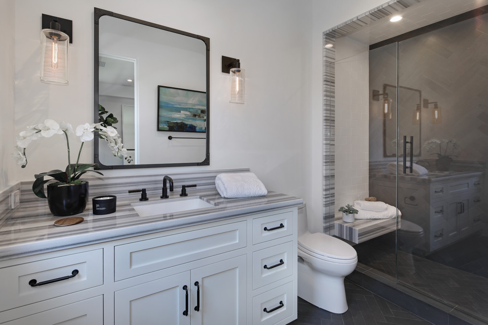 Design ideas for a traditional shower room bathroom in Los Angeles with shaker cabinets, white cabinets, an alcove shower, a one-piece toilet, grey tiles, white tiles, metro tiles, white walls, a submerged sink, grey floors, a hinged door and grey worktops.