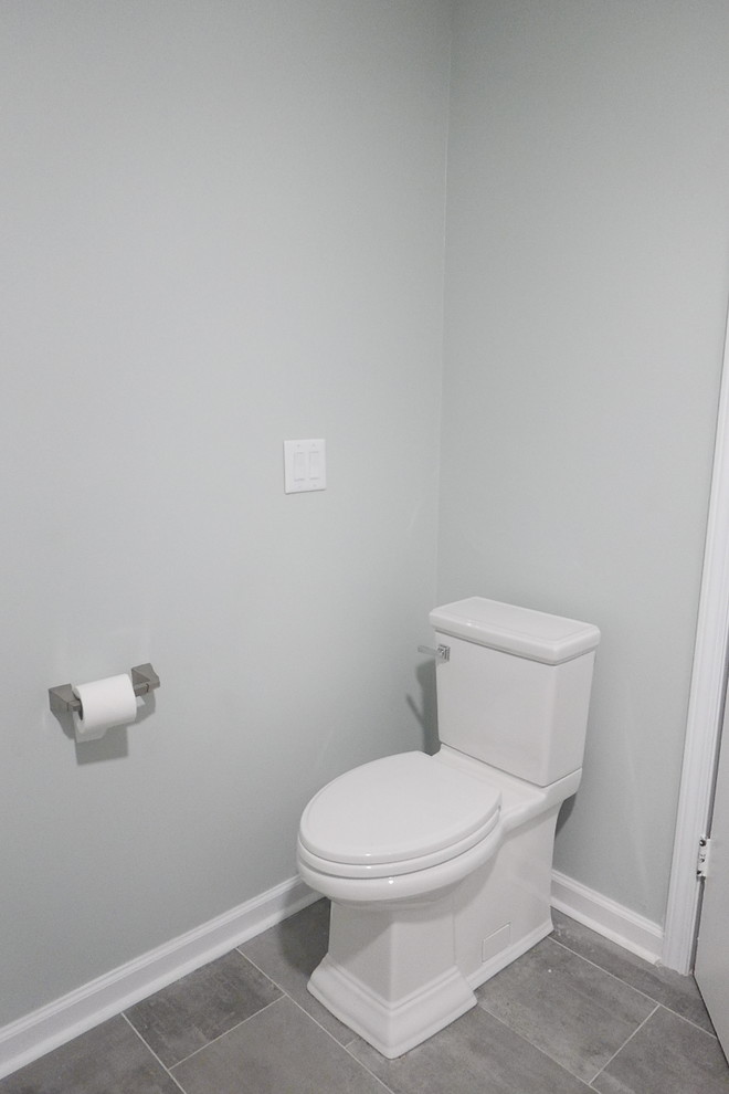 Пример оригинального дизайна: туалет среднего размера в стиле неоклассика (современная классика) с фасадами в стиле шейкер, серыми фасадами, раздельным унитазом, белой плиткой, керамогранитной плиткой, зелеными стенами, полом из керамогранита, врезной раковиной, столешницей из искусственного кварца, серым полом и белой столешницей