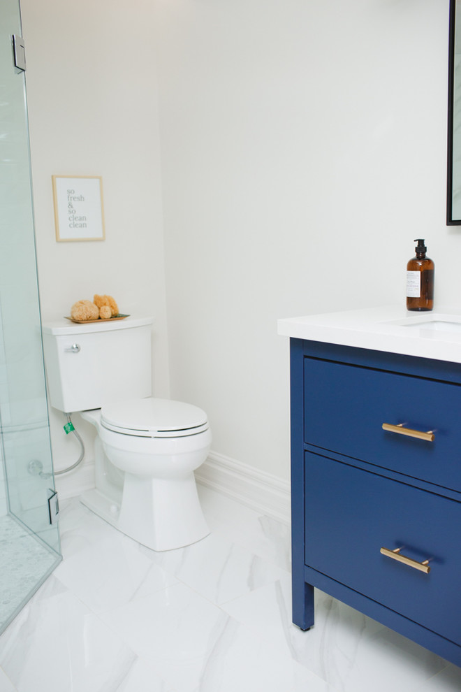Exempel på ett litet klassiskt badrum med dusch, med släta luckor, blå skåp, en hörndusch, en toalettstol med hel cisternkåpa, vit kakel, marmorkakel, grå väggar, klinkergolv i porslin, ett undermonterad handfat, bänkskiva i kvartsit, vitt golv och dusch med gångjärnsdörr