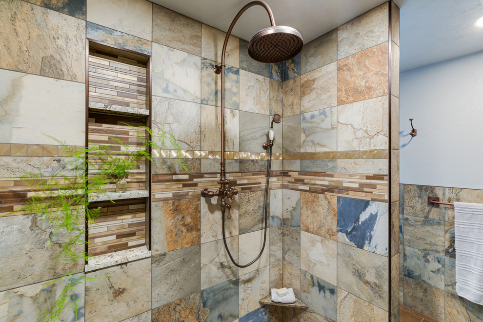 Cette image montre une grande salle de bain principale chalet en bois brun avec une baignoire indépendante, une douche ouverte, un mur bleu, une vasque, un plan de toilette en granite, un sol marron, aucune cabine et un plan de toilette multicolore.