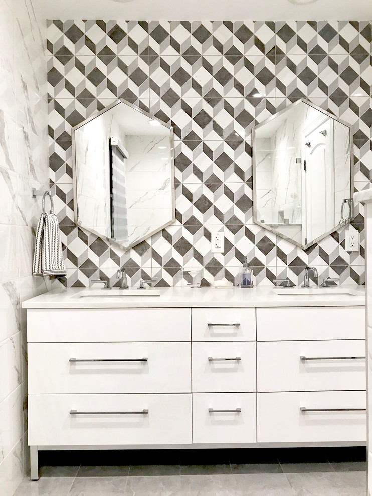 Foto på ett funkis vit badrum, med vita skåp, grå kakel, porslinskakel, klinkergolv i porslin, ett undermonterad handfat, bänkskiva i kvartsit och grått golv