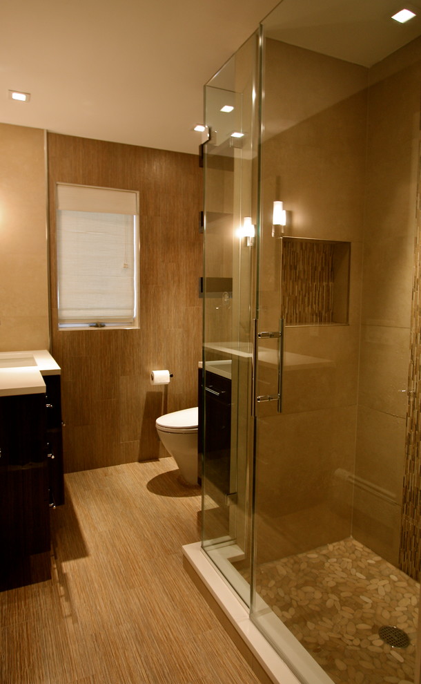 Trendy pebble tile bamboo floor alcove shower photo in New York with an undermount sink and beige walls