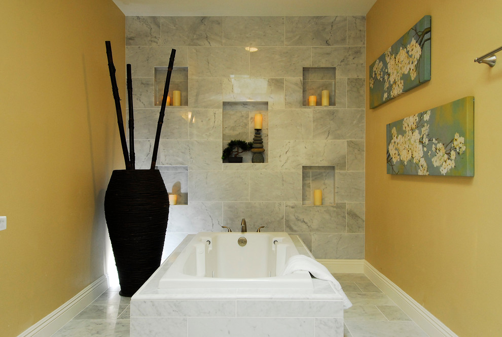 Modelo de cuarto de baño principal actual con bañera encastrada, baldosas y/o azulejos grises y paredes blancas