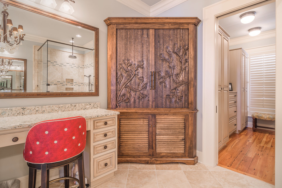 Example of a large classic master travertine floor and beige floor corner shower design in Charleston with terrazzo countertops, furniture-like cabinets, distressed cabinets, blue walls, an undermount sink and a hinged shower door