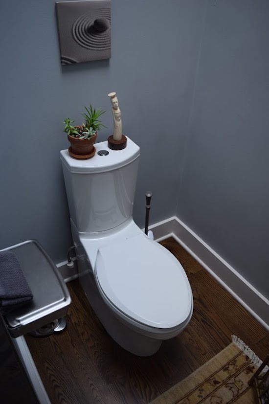 Réalisation d'un grand WC et toilettes bohème avec un placard avec porte à panneau encastré, des portes de placard grises, WC à poser, un carrelage multicolore, mosaïque, un mur gris, parquet foncé, un lavabo encastré et un plan de toilette en marbre.