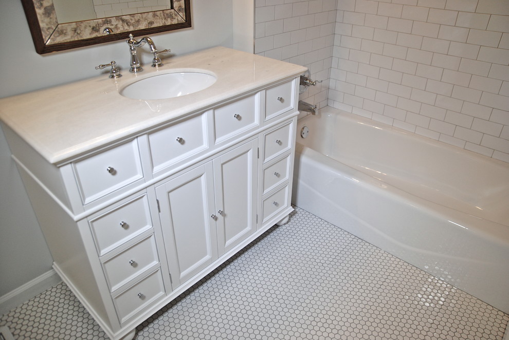 Идея дизайна: ванная комната среднего размера в стиле неоклассика (современная классика) с врезной раковиной, белыми фасадами, мраморной столешницей, душем над ванной, белой плиткой, керамогранитной плиткой, серыми стенами, полом из керамогранита и душевой кабиной