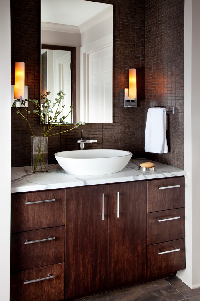 Idee per una stanza da bagno chic con lavabo a bacinella, ante lisce, ante in legno bruno, top in marmo e piastrelle marroni