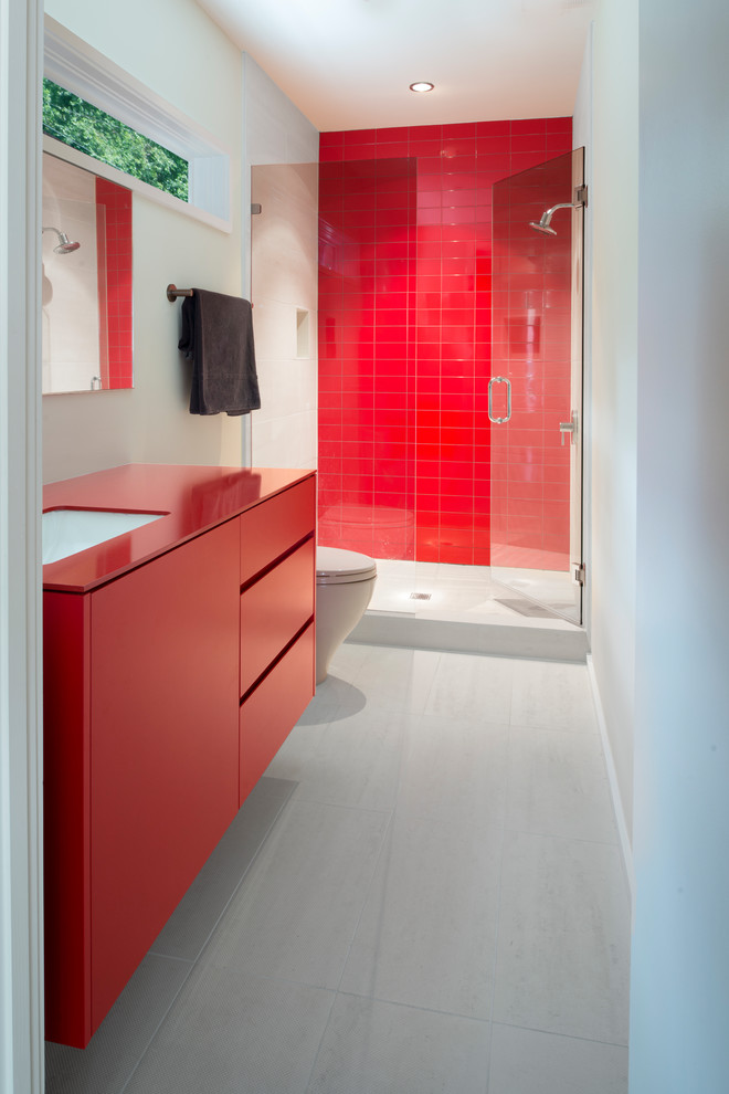Modernes Duschbad mit flächenbündigen Schrankfronten, roten Schränken, Duschnische, roten Fliesen, weißer Wandfarbe, Unterbauwaschbecken, weißem Boden, Falttür-Duschabtrennung und roter Waschtischplatte in Atlanta