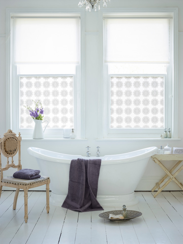 Diseño de cuarto de baño romántico con bañera exenta, suelo de madera pintada y ventanas