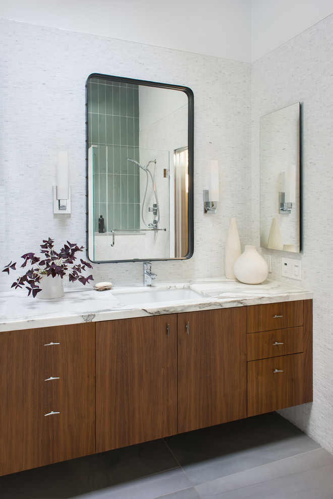 Réalisation d'une salle de bain vintage avec un placard à porte plane, des portes de placard marrons, un carrelage blanc, mosaïque, un lavabo encastré et un sol gris.