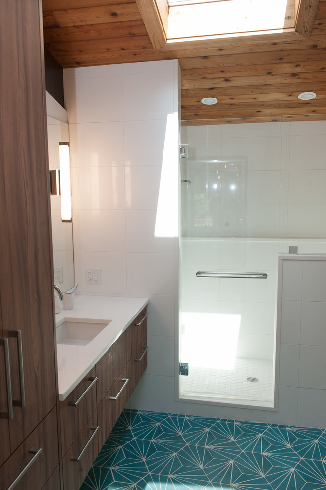 На фото: главная ванная комната среднего размера в стиле ретро с плоскими фасадами, белой плиткой, полом из цементной плитки, врезной раковиной, столешницей из искусственного кварца, бирюзовым полом и душем с распашными дверями