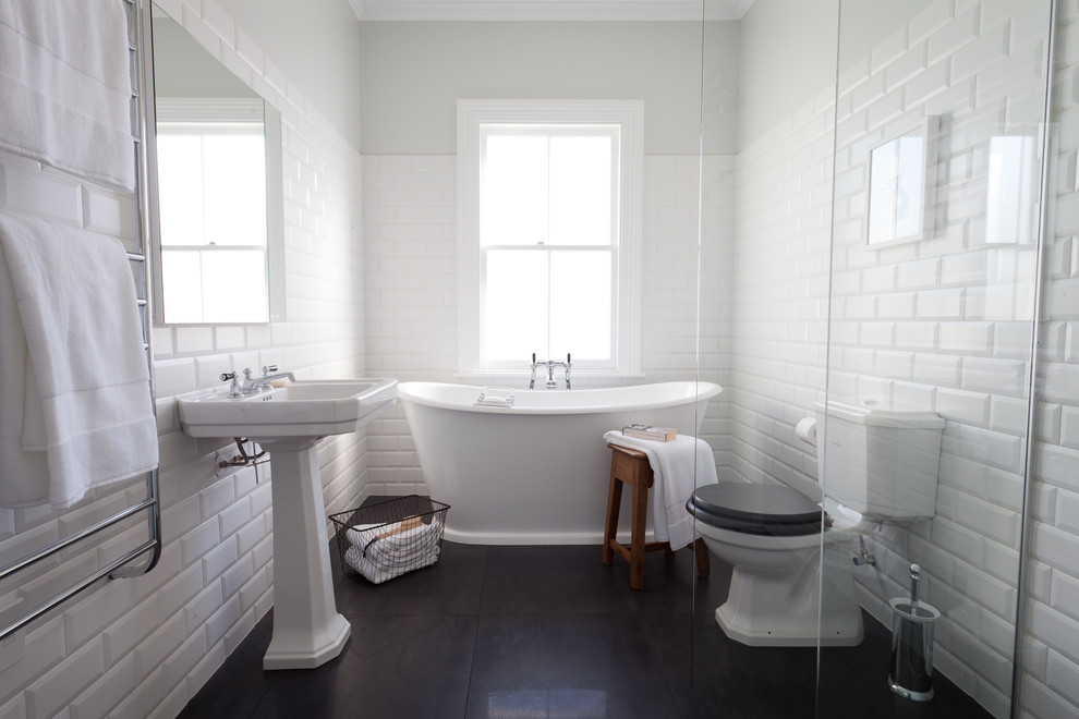 Idéer för att renovera ett vintage badrum, med ett piedestal handfat, ett fristående badkar, en öppen dusch, en toalettstol med separat cisternkåpa, vit kakel, tunnelbanekakel, vita väggar och klinkergolv i porslin