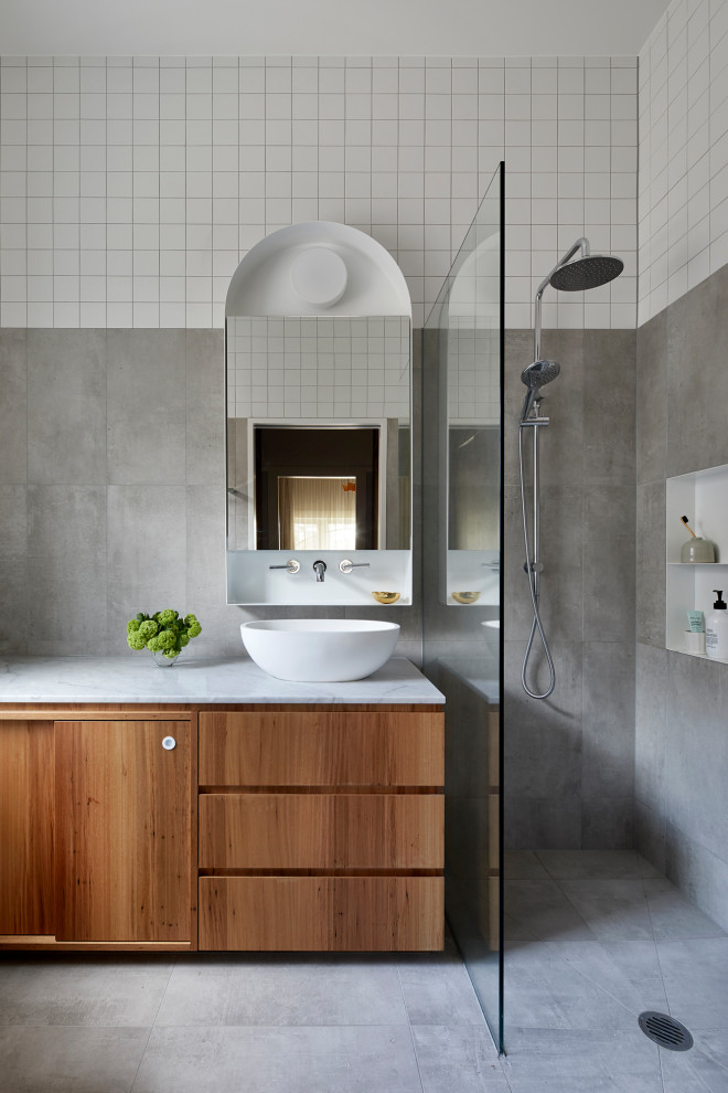 Example of a mid-sized trendy 3/4 gray tile and porcelain tile porcelain tile and gray floor alcove shower design in Melbourne with medium tone wood cabinets, a vessel sink, white countertops and flat-panel cabinets