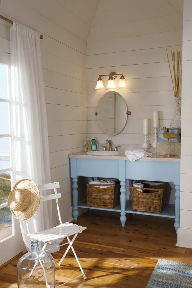 Cette photo montre une salle de bain bord de mer avec un lavabo posé et des portes de placard bleues.